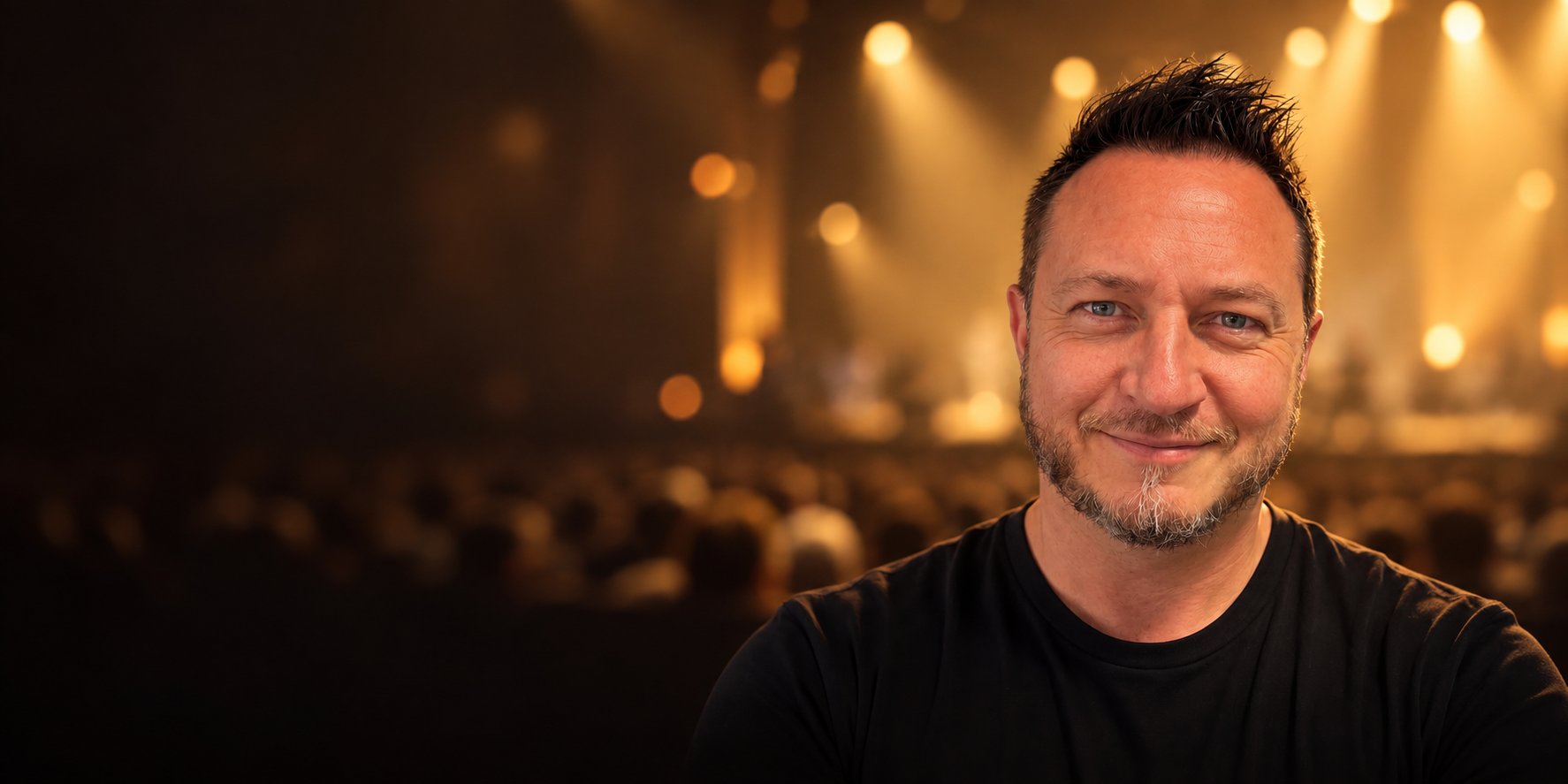 Justin Sokol on stage under golden lights